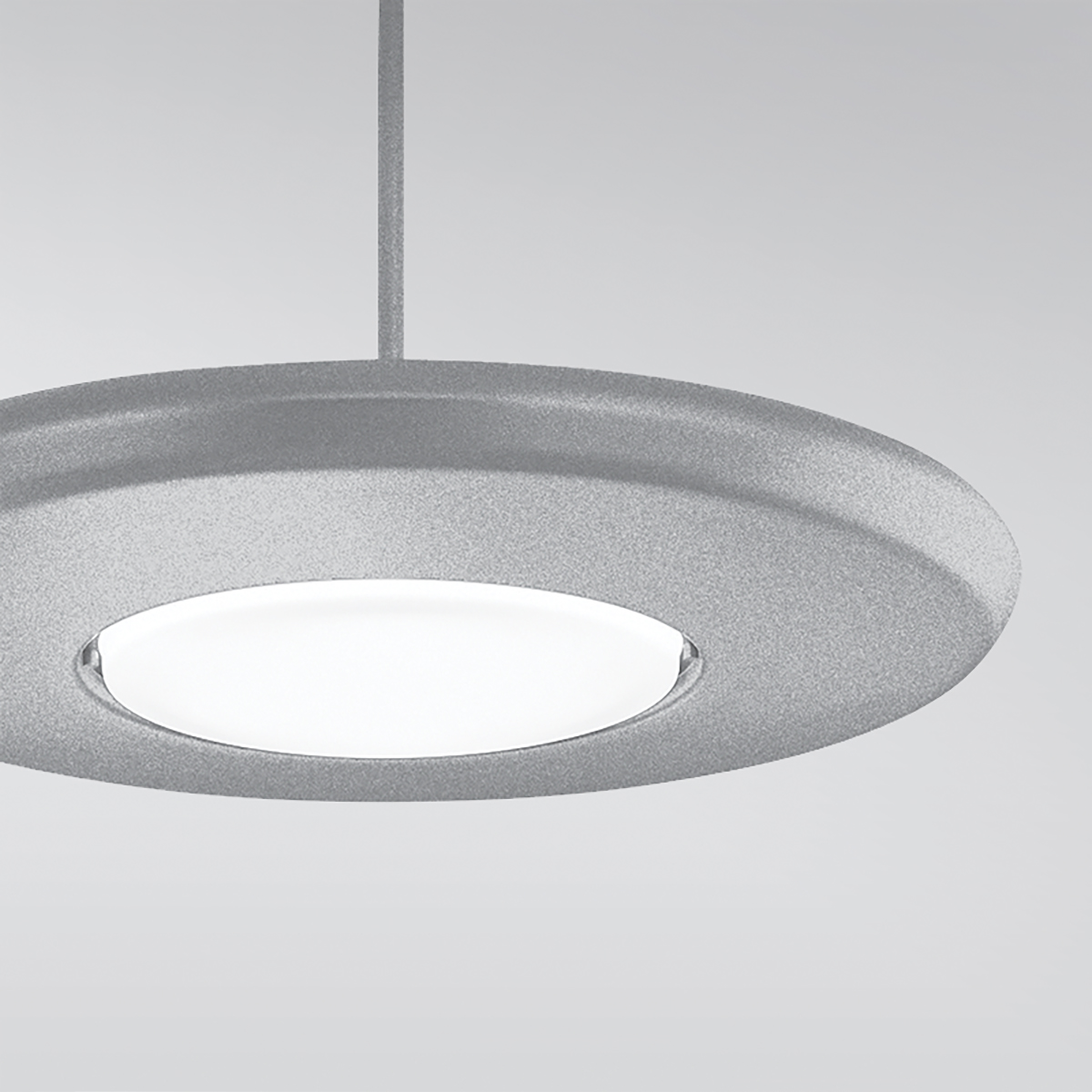 A round, disc-shaped pendant with a luminous downlight diffuser in the center cropped