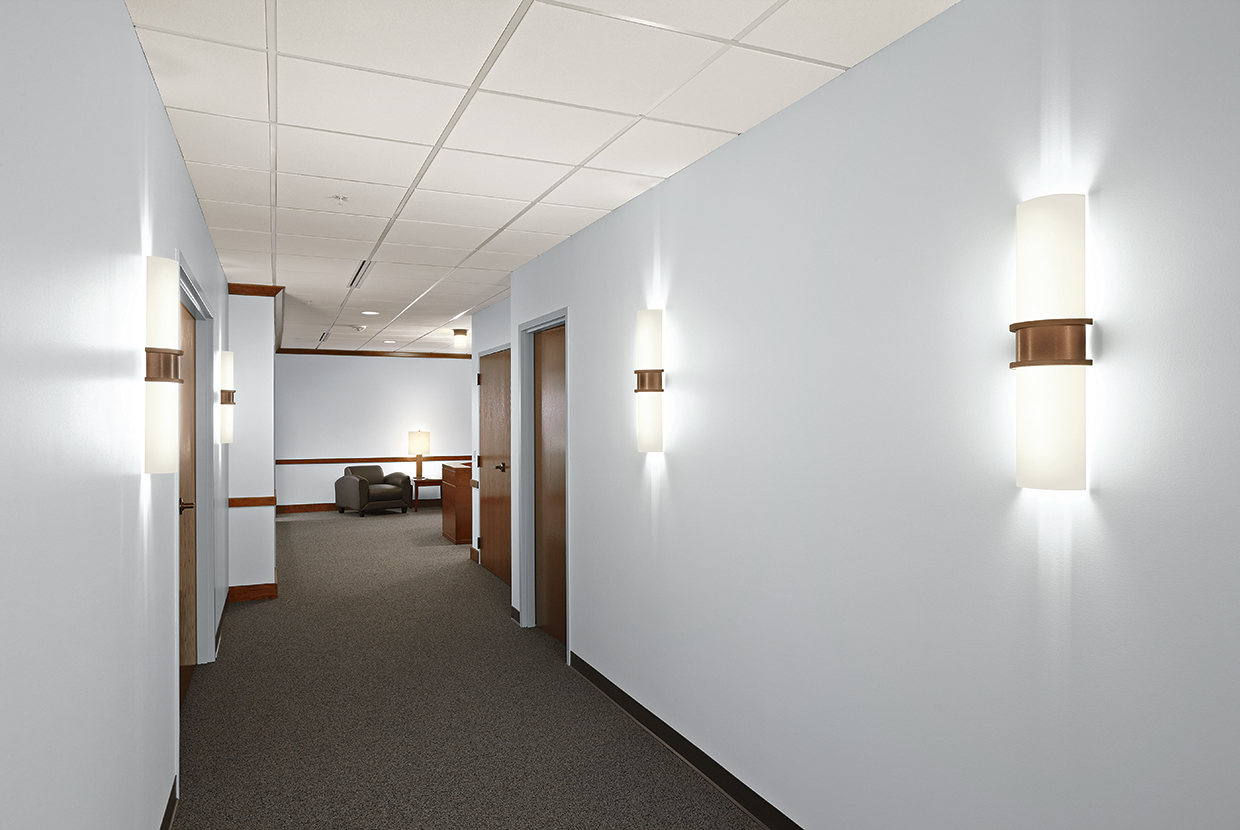 Pila sconces are ideal for hotel, office, or apartment lighting applications, seen here alongside doors in an office.