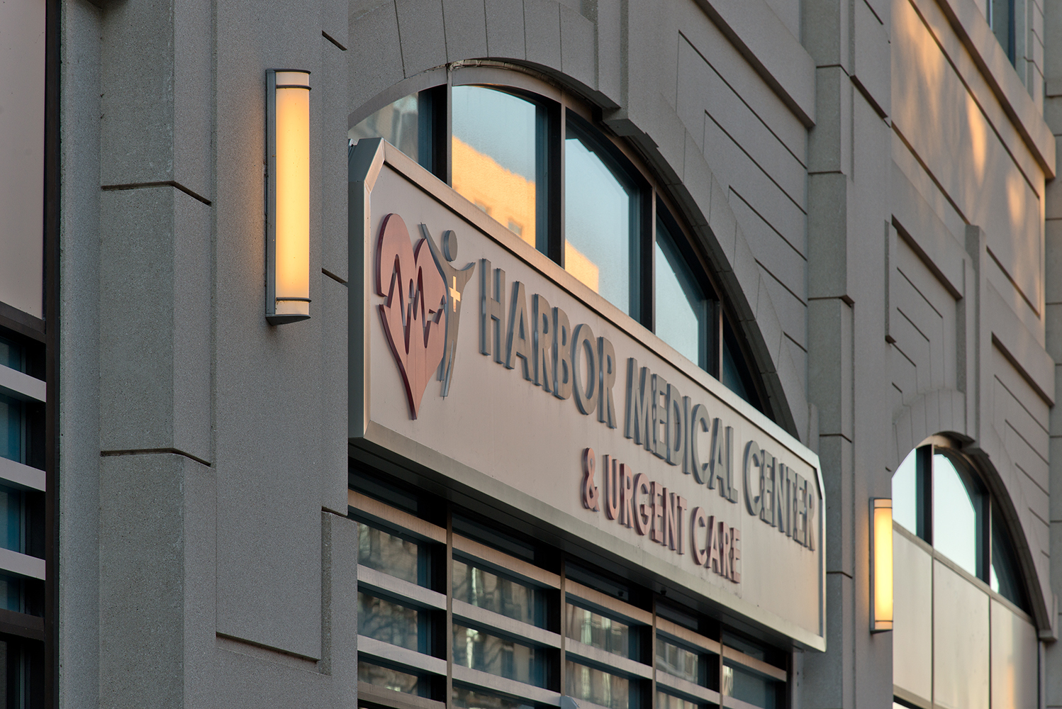 Raven outdoor light fixtures along a large medical center sign, mounted vertically.